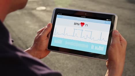 Mann-hält-Tablet-Gerät-seine-EKG-überwachen