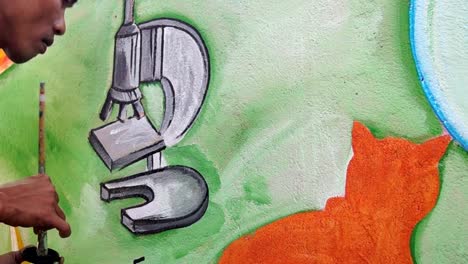 Mural-painter-draws-a-microscope-image-on-school-wall.