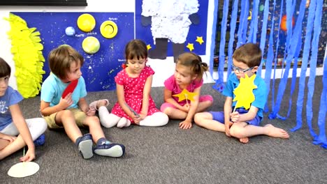 Educador,-rodeado-por-los-niños-en-el-jardín-de-la-infancia