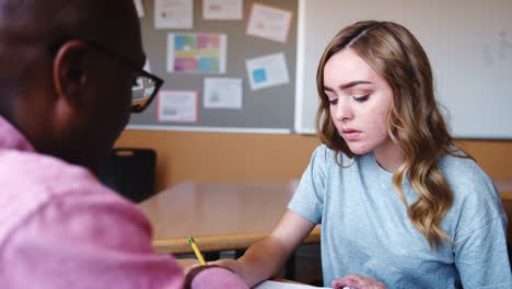 High-School-Lehrer-geben-Studentin-Einzelunterricht-am-Schreibtisch