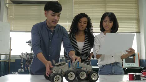 Team-of-electronics-engineer-working-together,-collaborating-on-a-project-to-build-robot.-People-with-technology-or-innovation-concept.