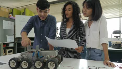 Equipo-de-ingeniero-electrónico-trabajando-juntos,-colaborando-en-un-proyecto-para-construir-el-robot.-Personas-con-el-concepto-de-tecnología-o-innovación.