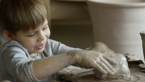 Cute-Boy-Playing-with-Wet-Pottery-Clay