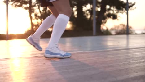 Close-up-of-female-basketball-player-legs-in-white-golf-socks-doing-dribbling-exersice-very-quickly,-run-backwards,-training-outdoors-on-the-local-court