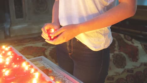 Mujer-sosteniendo-la-vela-cerca-de-altar-en-la-iglesia.