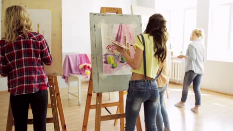 students-with-easels-painting-at-art-school