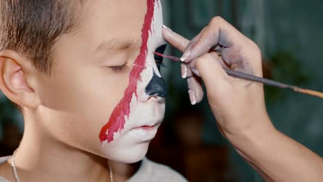 Make-up-artist-conforma-al-niño-hacen-de-halloween.-Arte-de-cara-de-Halloween-infantil.