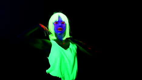 Woman-with-UV-face-paint,-wig,-glowing-clothing-dancing-in-front-of-camera,-Half-body-shot.-Caucasian-woman.-.