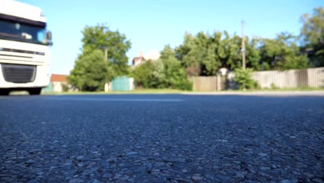 Blurred-shot-of-truck-driving-along-highway-in-country-road.-Lorry-rides-through-the-rural.-Slow-motion-Low-angle-view-Close-up