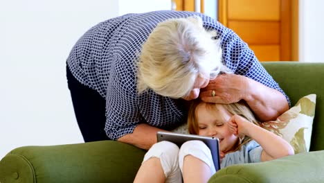 Großmutter-und-Enkelin-mit-digital-Tablette-im-Wohnzimmer-4k