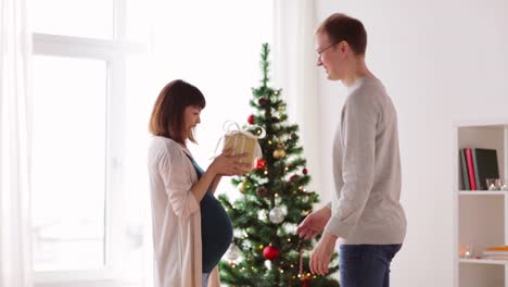 husband-giving-christmas-present-to-pregnant-wife