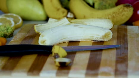 Hombre-es-poner-un-plátano-pelado-en-la-tabla-de-cortar-en-cámara-lenta
