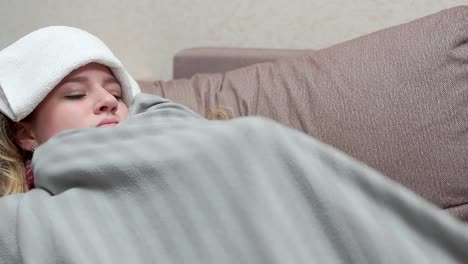 Una-adolescente-está-cubierta-con-una-manta,-su-fiebre,-dolor-de-cabeza,-gripe.