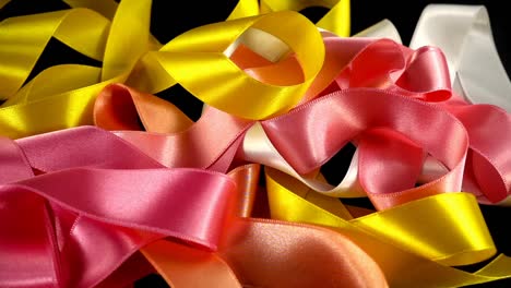 Satin-ribbon-on-a-black-background.-Slow-motion.