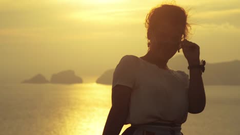 Hermosa-joven-vistiendo-moda-colorido-vestido-con-falda-y-sombrero-posando-para-la-cámara-al-atardecer-en-la-isla-de-Ponza-montaña-Costa-Italia.