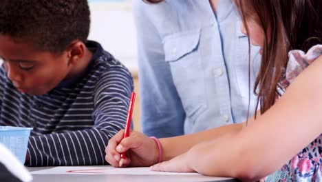 Teacher-helping-elementary-schoolchildren-in-art-class