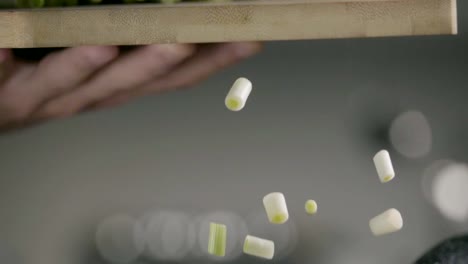 Falling-of-green-onion-into-the-frying-pan.-Slow-motion-240-fps