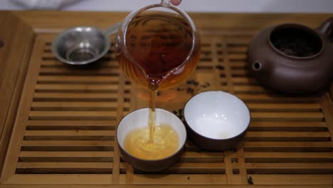 Ich-gieße-Tee-aus-Chahai-in-Schalen.-Chinesische-Tee-Zeremonie.