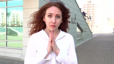 Porträt-der-rothaarige-junge-Frau,-die-im-Freien-an-windigen-Tag-beten