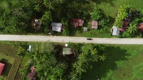 Vista-aérea-siguiente-coche-en-carretera.-Complejo-de-colinas-de-chocolate,-Batuan,-Filipinas.