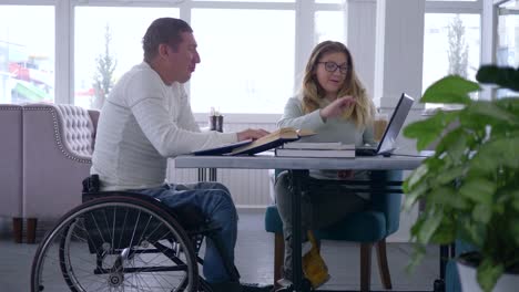 education-for-handicapped,-diseased-student-senior-man-in-wheelchair-with-tutor-women-during-home-teaching-courses-using-laptop-computer