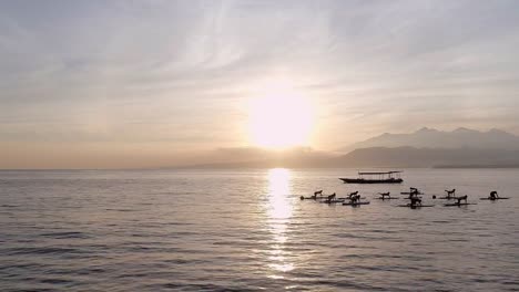 Clase-de-Yoga-amanecer-en-Stand-Up-Paddle-Boards-en-el-océano-de-la-calma