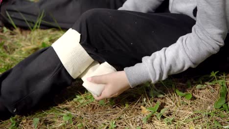 Close-up-of-winding-an-elastic-bandage-on-the-knee.-Injury-in-nature