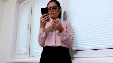 Woman-squeezing-stress-ball-and-using-smartphone