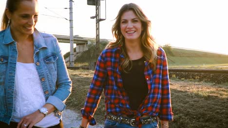 two-beautiful-and-young-women-walking-and-talking-with-skateboard