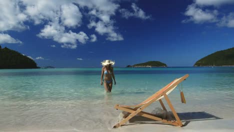 mujer-de-sombrero-de-paja-de-bikini-caminando-hacia-la-orilla-en-la-playa-perfecta-en-el-Caribe