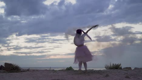 Sensual-joven-con-maquillaje-brillante-en-un-vestido-rosado-bailando-con-bombas-de-humo-en-la-orilla-del-río.-La-danza-de-una-tierna-chica-dulce-con-un-peinado-de-flor.-Cámara-lenta.