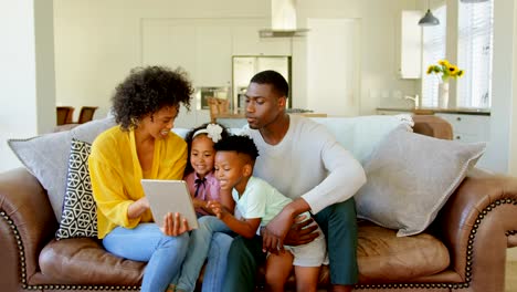 Vorderansicht-der-Familie-black-mit-digital-Tablette-im-Wohnzimmer-zu-Hause-4k