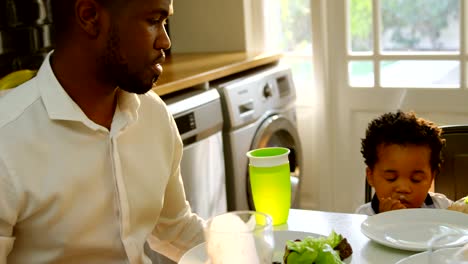 Young-black-family-having-food-at-dining-table-in-kitchen-of-comfortable-home-4k