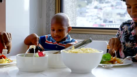 Family-having-food-at-dining-table-in-a-comfortable-home-4k