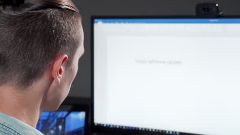 Rear-view-cropped-shot-of-a-computer-programmer-working-late-in-IT-office