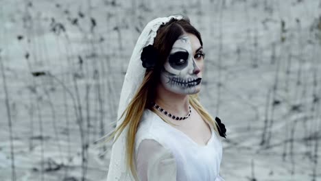 Una-mujer-con-maquillaje-espeluznante-para-Halloween-con-un-vestido-de-novia-blanco.-A-cámara-lenta.-Hd