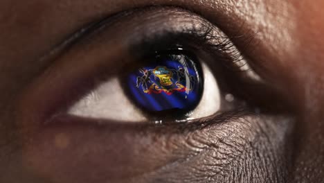 Woman-black-eye-in-close-up-with-the-flag-of-Pennsylvania-state-in-iris,-united-states-of-america-with-wind-motion.-video-concept