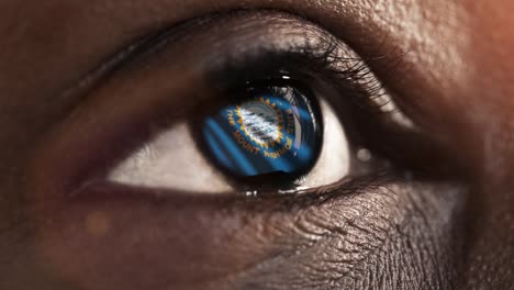 Woman-black-eye-in-close-up-with-the-flag-of-South-Dakota-state-in-iris,-united-states-of-america-with-wind-motion.-video-concept