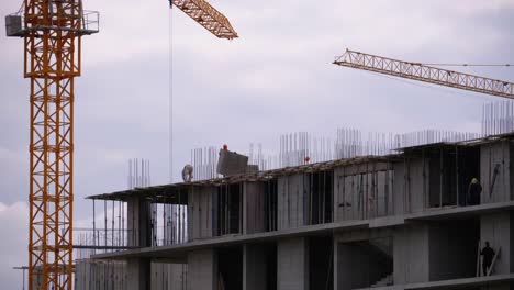 Constructores-en-el-borde-de-un-rascacielos-en-construcción.-Trabajadores-en-una-obra-de-construcción