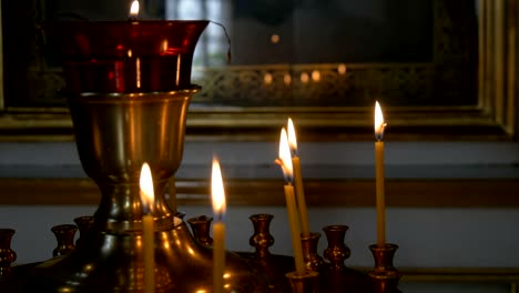 Burning-candles-in-front-of-the-altar-in-the-church.-Praying-parishioner-of-the-church.