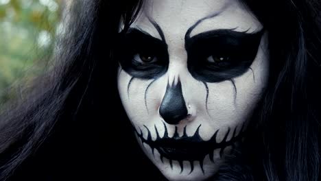 Young-woman-in-scary-black-and-white-halloween-make-up-looking-into-camera