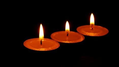 dolly,Close-up-candle-is-burning-on-black-background.