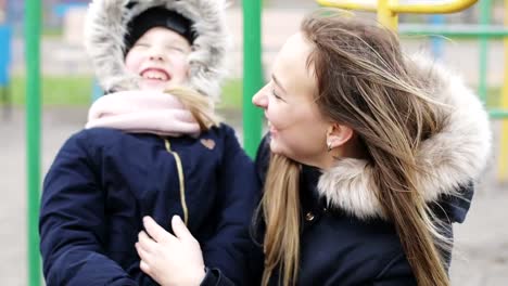 The-girls-are-dressed-in-warm-jackets-with-hoods-outdoors.