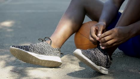 Primer-plano-de-las-piernas-del-hombre-afroamericano,-atar-cordones-de-los-zapatos-de-jugador-de-baloncesto