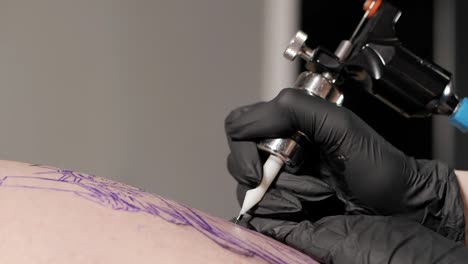 Tattoo-artist-make-tattoo-at-the-studio,close-up