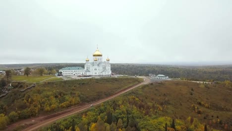 Aérea-vista-de-iglesia-y-punto-de-referencia,-cúpulas-doradas-amarillo-al-aire-libre-en-otoño.-Clip.-Vista-superior-de-la-iglesia-en-otoño