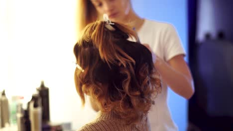 Young-stylist-girl-makes-hairstyle-to-a-lady