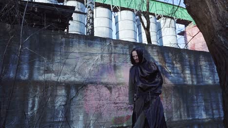 Grim-reaper-or-angel-of-death-on-INDUSTRIAL-URBANISTIC-LANDSCAPE-Goes-to-the-camera-and-closes-the-lens-by-hand.