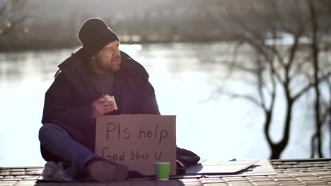 Homeless-man-eating-sandwich-and-begging-for-help