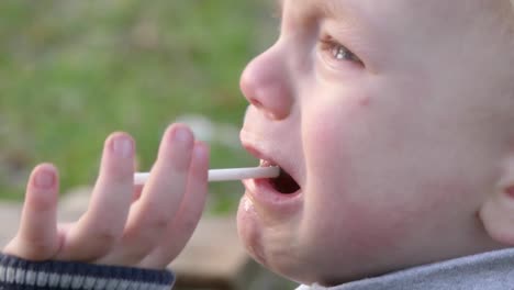 Un-niño-de-dos-años-está-llorando-con-el-caramelo-en-la-boca.